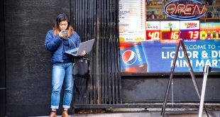 Small Business software In Boise Id Dans Woman In Blue Jeans Holding Macbook Pro Standing Against Black Wall